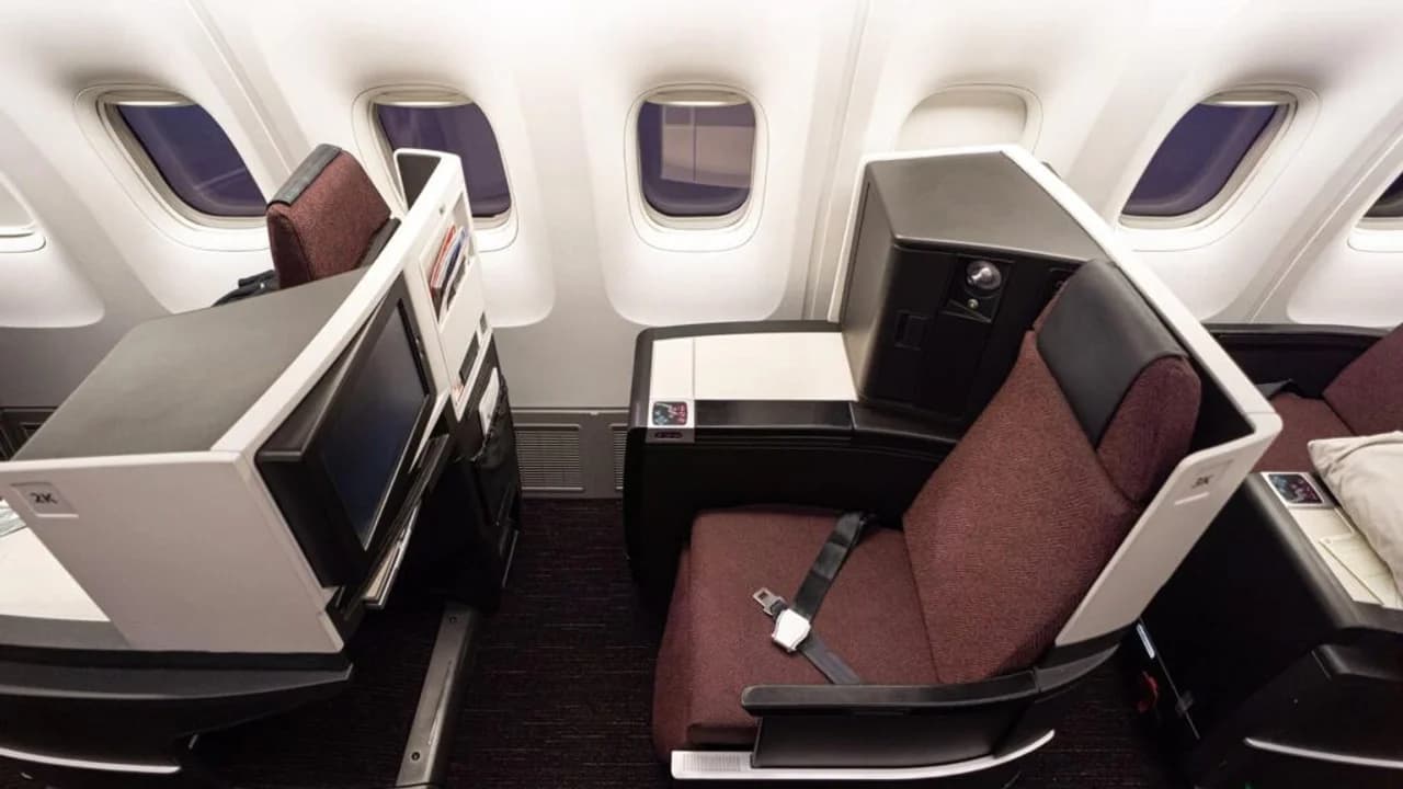 Japan Airlines Sky Suite business class seat with thick mattress pad and privacy dividers