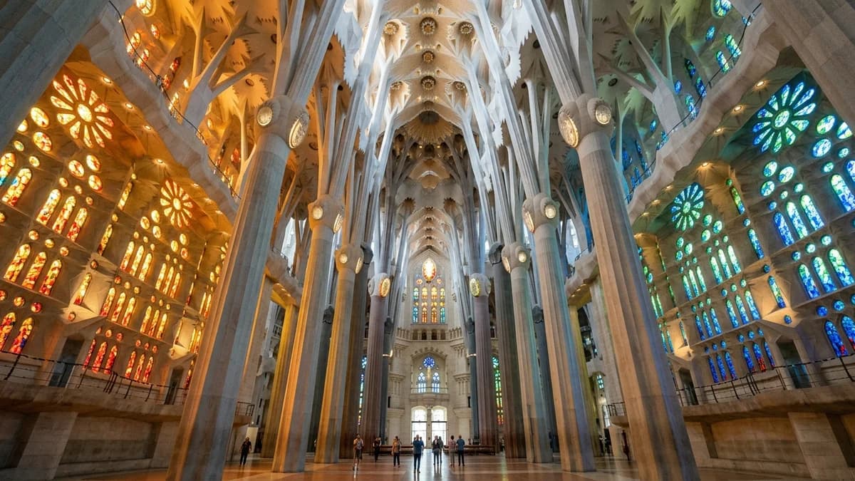 Interior of La Sagrada Familia with tree-like columns and colorful stained-glass light