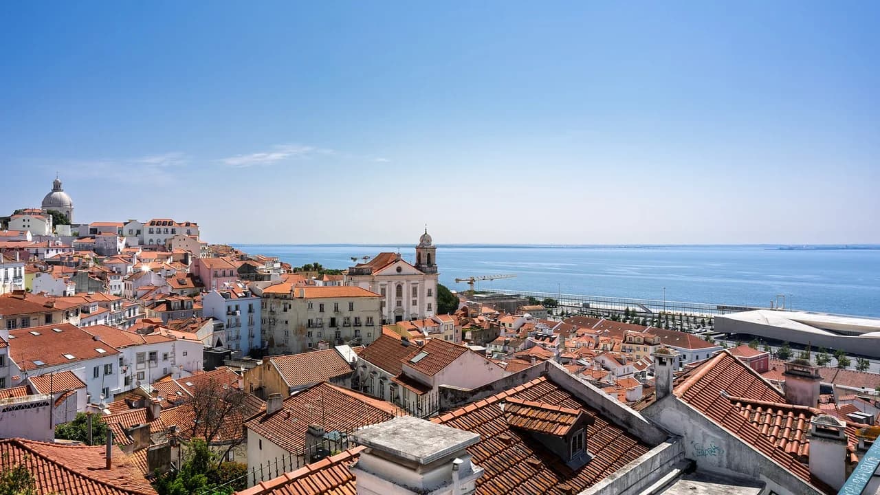 Lisbon terracotta rooftops overlooking Tagus River at golden hour